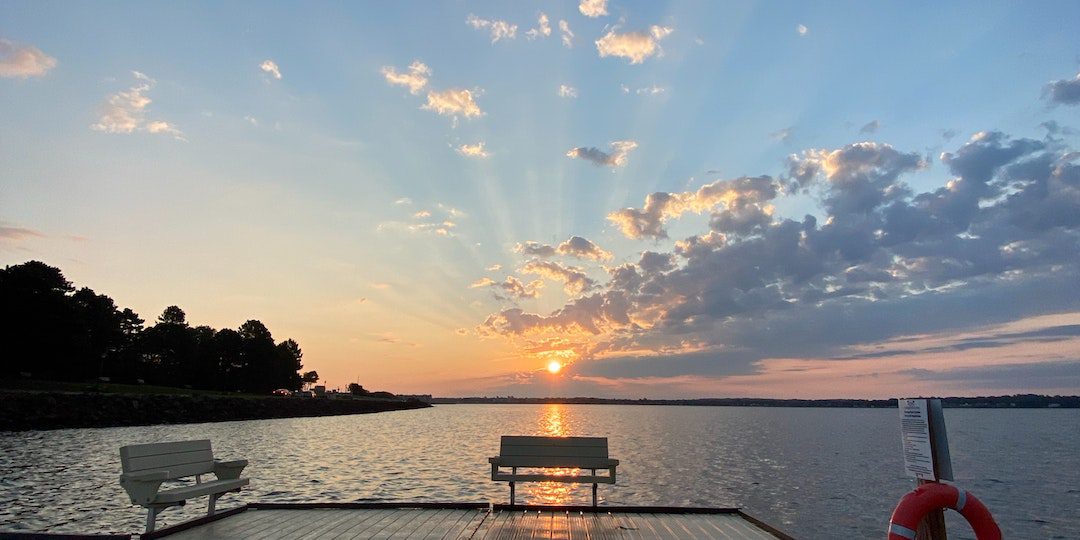 Photo of Wooden Dock with Benches at Sunset